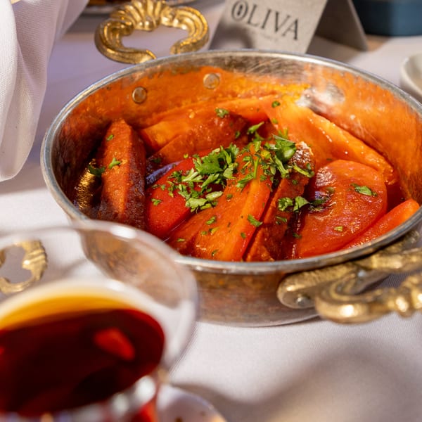 Braised carrots and other vegetables in a copper pot, garnished with fresh parsley at Oliva by El Turco.